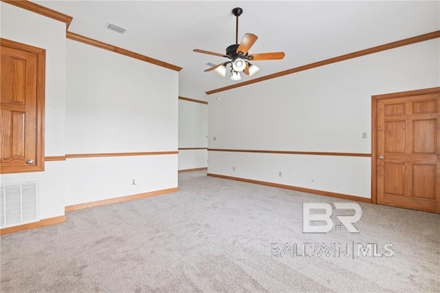 empty room featuring ceiling fan, light carpet, and ornamental molding