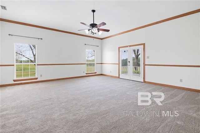 carpeted empty room featuring a wealth of natural light, crown molding, french doors, and ceiling fan