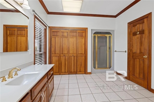 bathroom with tile patterned flooring, vanity, ornamental molding, and walk in shower