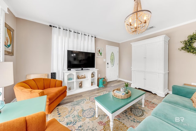 living room featuring light hardwood / wood-style flooring, a chandelier, and ornamental molding