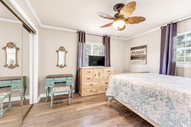 bedroom featuring multiple windows, a closet, light hardwood / wood-style flooring, and ceiling fan