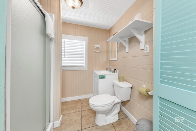 bathroom with tile patterned floors, a shower with door, wooden walls, sink, and toilet