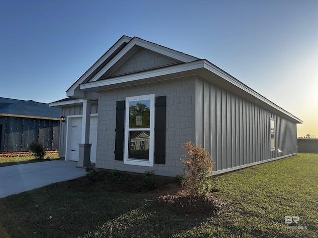 13729 Shea Cir, Foley, AL 36535 - property exterior at dusk with board and batten siding, a lawn, an attached garage, and concrete driveway