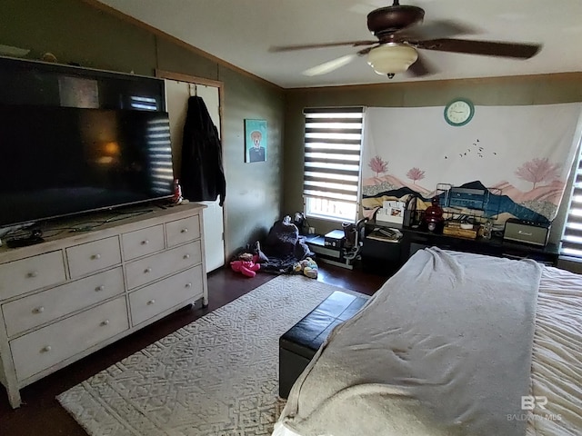 bedroom with ceiling fan, dark wood-type flooring, and vaulted ceiling