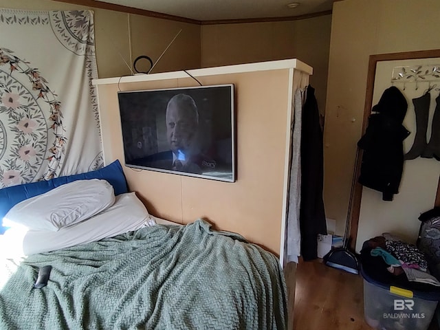 bedroom featuring wood-type flooring and ornamental molding