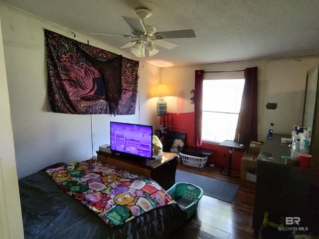 bedroom featuring hardwood / wood-style floors, a textured ceiling, and ceiling fan