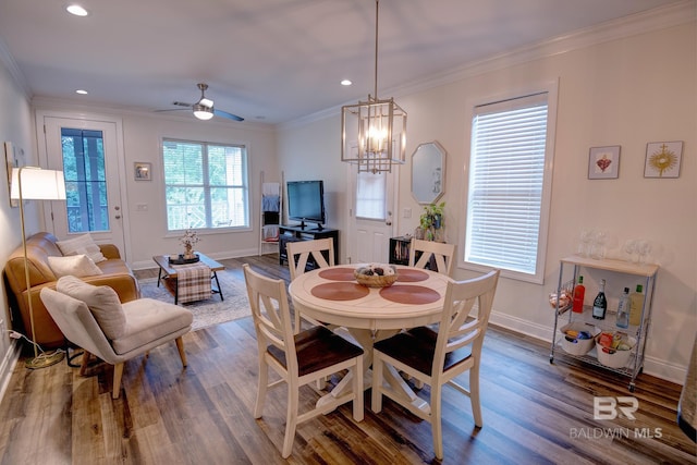 dining space with ceiling fan with notable chandelier, ornamental molding, and dark hardwood / wood-style flooring