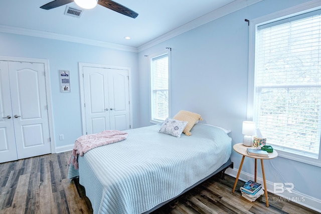 bedroom with multiple windows, dark wood-type flooring, and ceiling fan