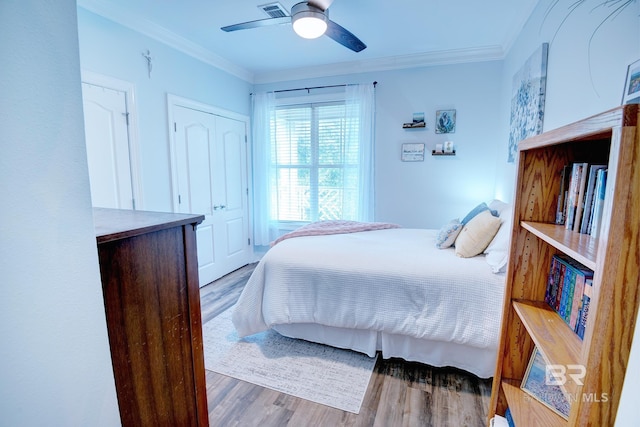 bedroom featuring ceiling fan, crown molding, and hardwood / wood-style floors