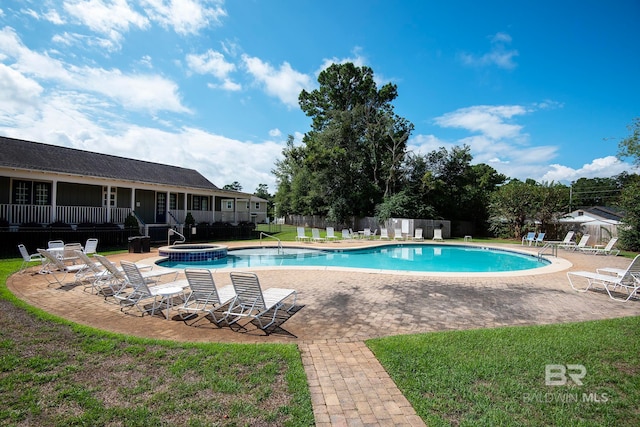 view of pool with a lawn and a patio area