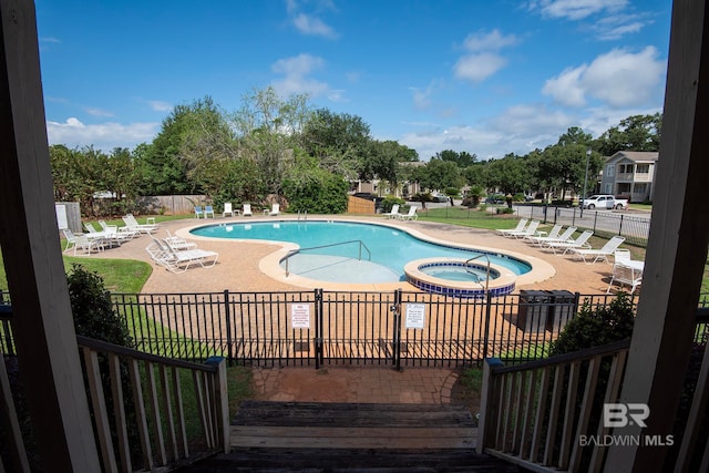 view of swimming pool with a patio area and a hot tub