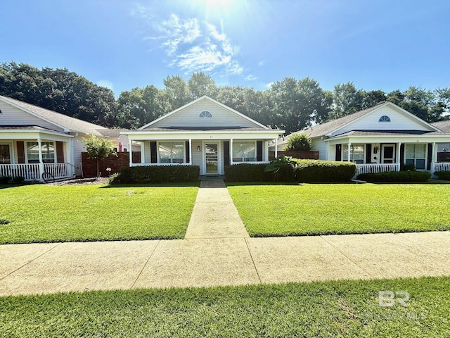 33 Cottage Dr, Fairhope, AL 36532 - bungalow with a porch, a front lawn, and brick siding