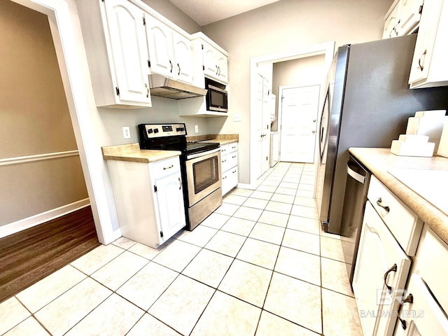 33 Cottage Dr, Fairhope, AL 36532 - kitchen with appliances with stainless steel finishes, under cabinet range hood, light countertops, white cabinets, and light tile patterned floors