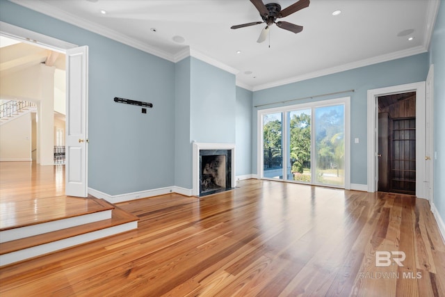 unfurnished living room with light wood-type flooring, ceiling fan, ornamental molding, and a premium fireplace