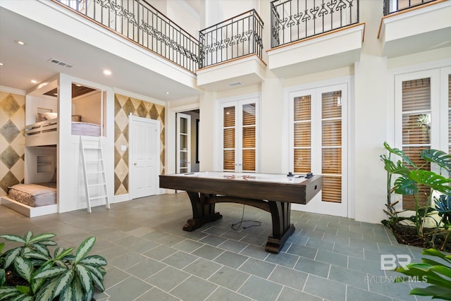 playroom with a towering ceiling and billiards