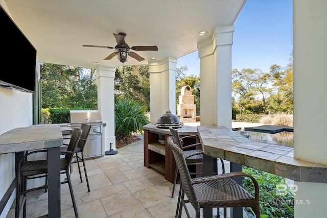 view of patio / terrace with ceiling fan, an outdoor bar, and an outdoor fireplace