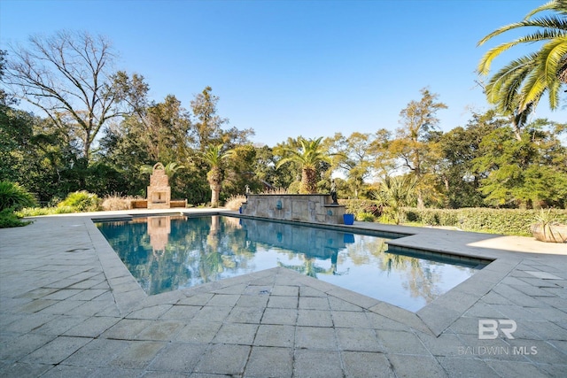 view of pool with a patio area and exterior fireplace