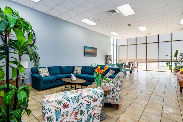 24160 Perdido Beach Blvd Unit 2073, Orange Beach, AL 36561 - living room with light tile patterned floors, a paneled ceiling, and a wall of windows