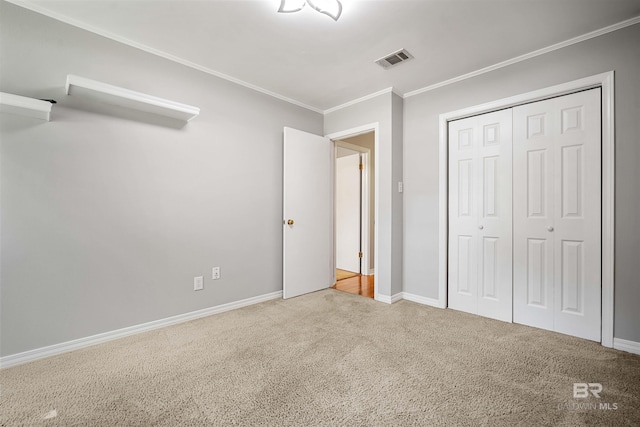 unfurnished bedroom with carpet floors, a closet, and crown molding