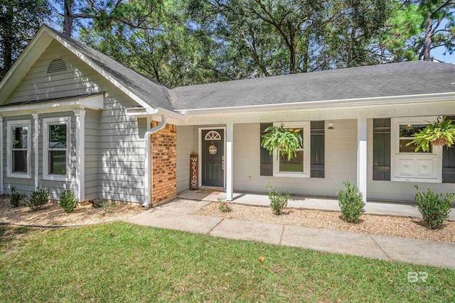 ranch-style house with covered porch and a front yard