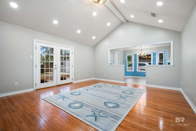 living room featuring a wealth of natural light, a chandelier, a textured ceiling, and hardwood / wood-style floors