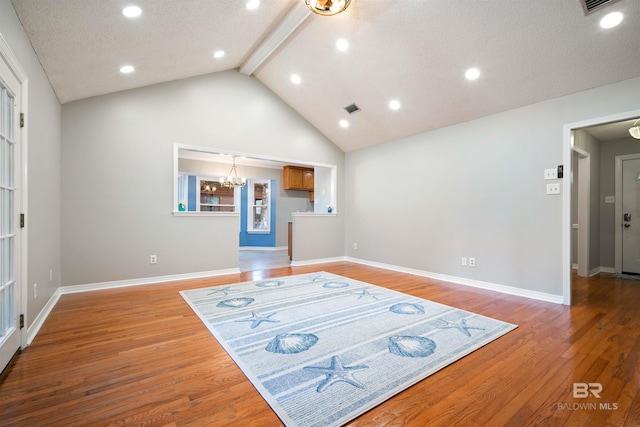 interior space with high vaulted ceiling, a textured ceiling, wood-type flooring, beam ceiling, and a chandelier