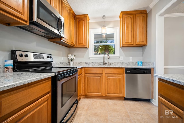 kitchen featuring crown molding, light stone countertops, sink, and stainless steel appliances