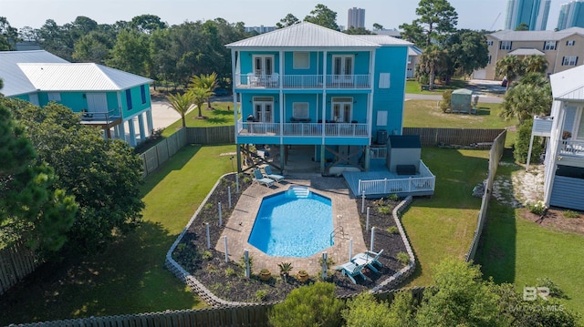 back of house with a balcony, a fenced in pool, and a patio