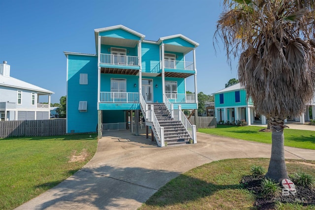 raised beach house with a front yard and a carport