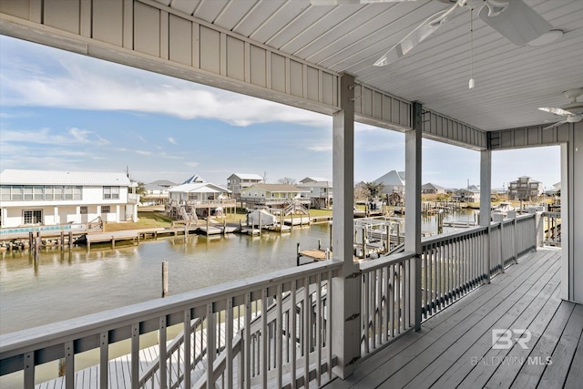 deck featuring a water view, ceiling fan, and a dock