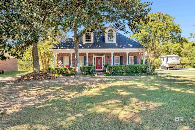 cape cod house featuring a front yard and covered porch