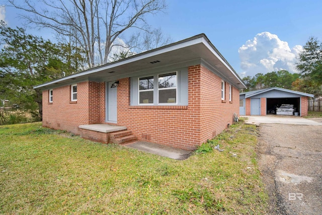 view of front facade featuring a garage, an outbuilding, and a front yard