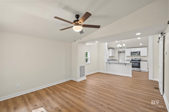 1096 S Pine St, Loxley, AL 36551 - unfurnished living room featuring a barn door, light wood-style flooring, recessed lighting, ceiling fan, and a chandelier