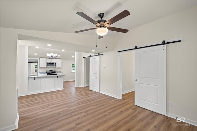 1096 S Pine St, Loxley, AL 36551 - unfurnished living room with a barn door, light wood-type flooring, ceiling fan, and recessed lighting
