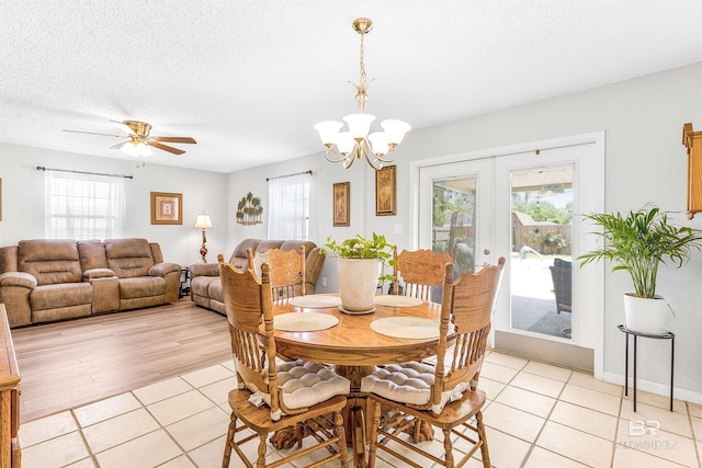 dining area featuring light tile patterned flooring, plenty of natural light, a textured ceiling, and french doors