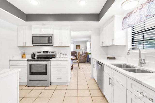 kitchen featuring white cabinetry, sink, stainless steel appliances, and light tile patterned flooring