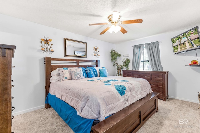 carpeted bedroom featuring ceiling fan and a textured ceiling