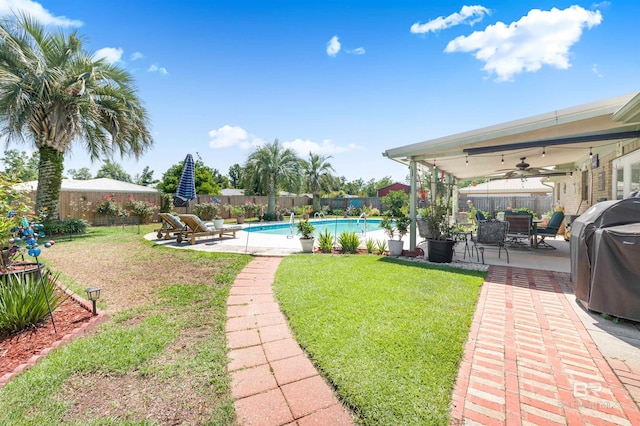 view of yard with a fenced in pool, a patio area, and ceiling fan