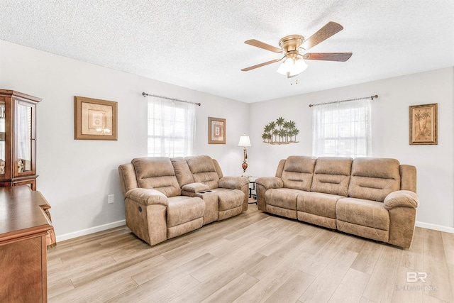 living room with plenty of natural light, a textured ceiling, and light wood-type flooring