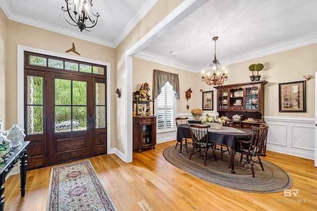 entrance foyer featuring crown molding, an inviting chandelier, and light hardwood / wood-style floors