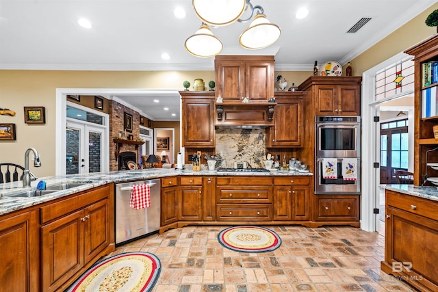 kitchen featuring sink, appliances with stainless steel finishes, backsplash, light stone counters, and ornamental molding