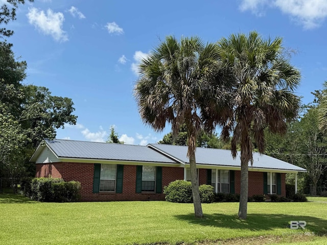 215 W Palm Ave, Foley, AL 36535 - ranch-style house featuring a front yard, brick siding, and a metal roof