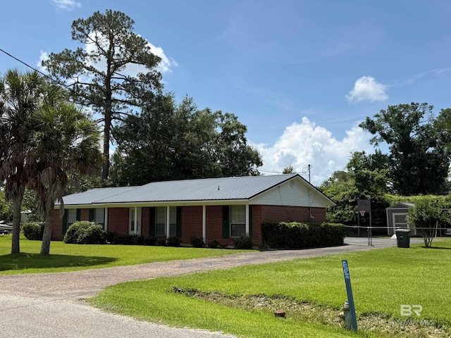 215 W Palm Ave, Foley, AL 36535 - ranch-style home with dirt driveway, a front lawn, and brick siding