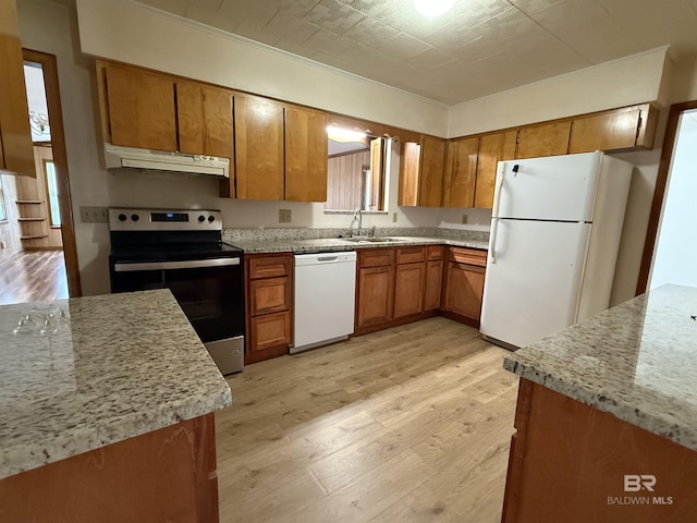 215 W Palm Ave, Foley, AL 36535 - kitchen featuring white appliances, under cabinet range hood, brown cabinetry, light wood-type flooring, and crown molding