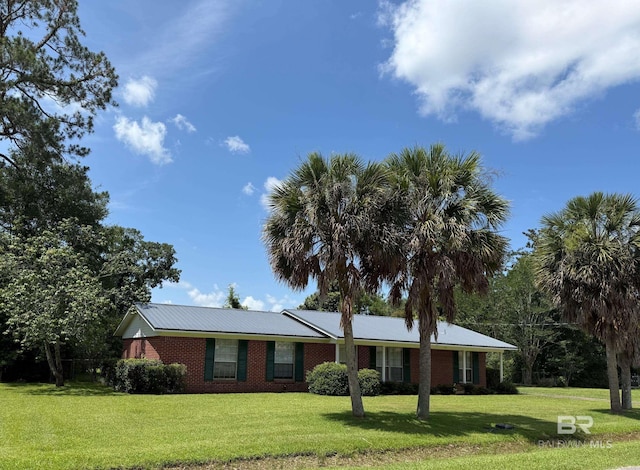 215 W Palm Ave, Foley, AL 36535 - ranch-style house featuring a front lawn, brick siding, and a metal roof