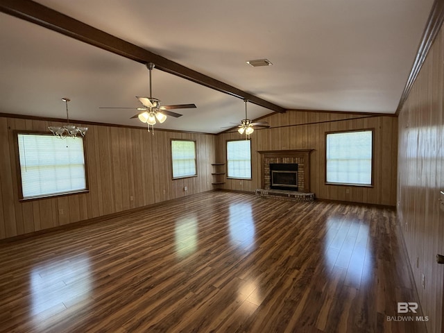 215 W Palm Ave, Foley, AL 36535 - unfurnished living room with dark wood-type flooring, a brick fireplace, ceiling fan, wood walls, and a chandelier
