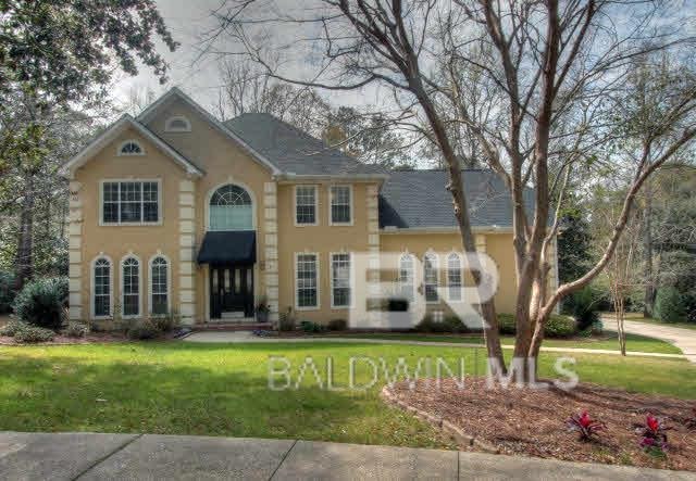 colonial house with a front lawn and stucco siding