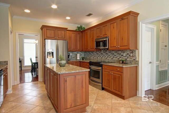 kitchen featuring stainless steel appliances, light tile patterned flooring, light stone countertops, and a center island