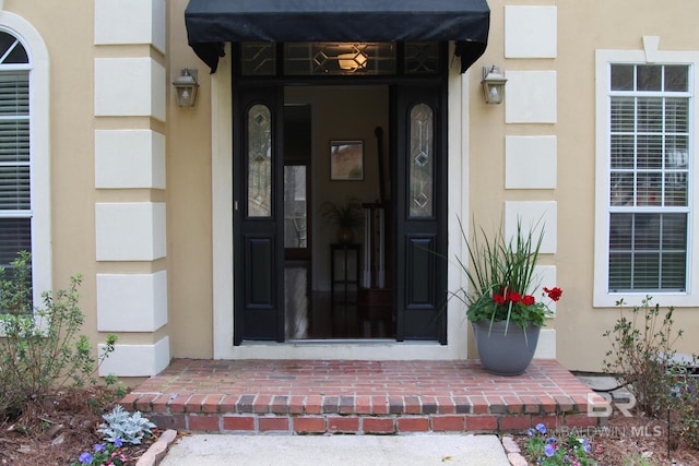 property entrance with stucco siding