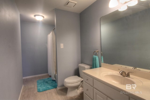 full bathroom with baseboards, a shower with shower curtain, vanity, and toilet